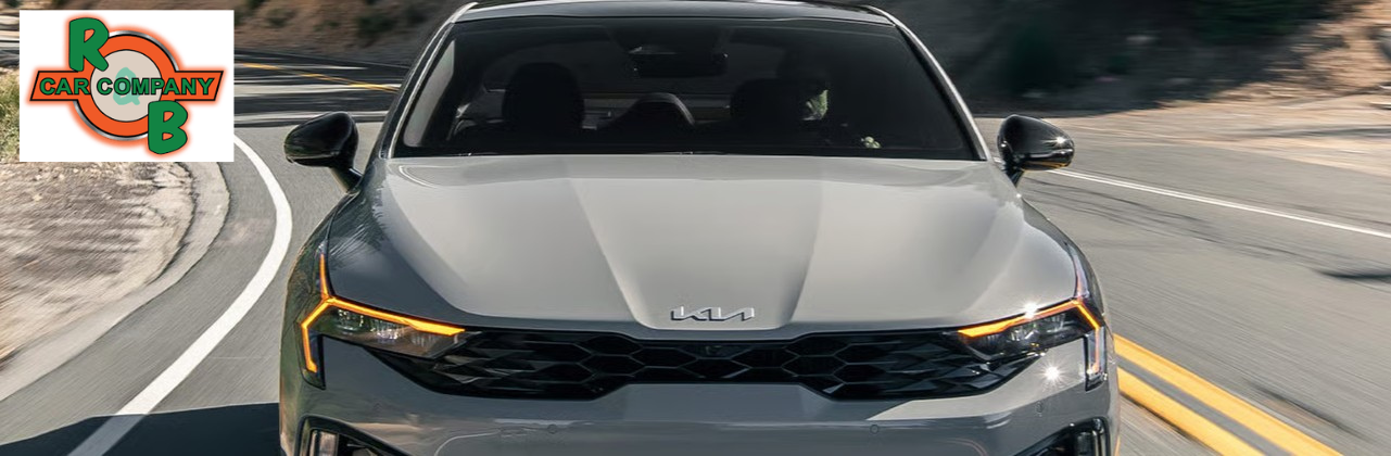 Kia K5 GT-Line sedan parked outside an R&B Car Company dealership in Indiana, showcasing sporty exterior styling.